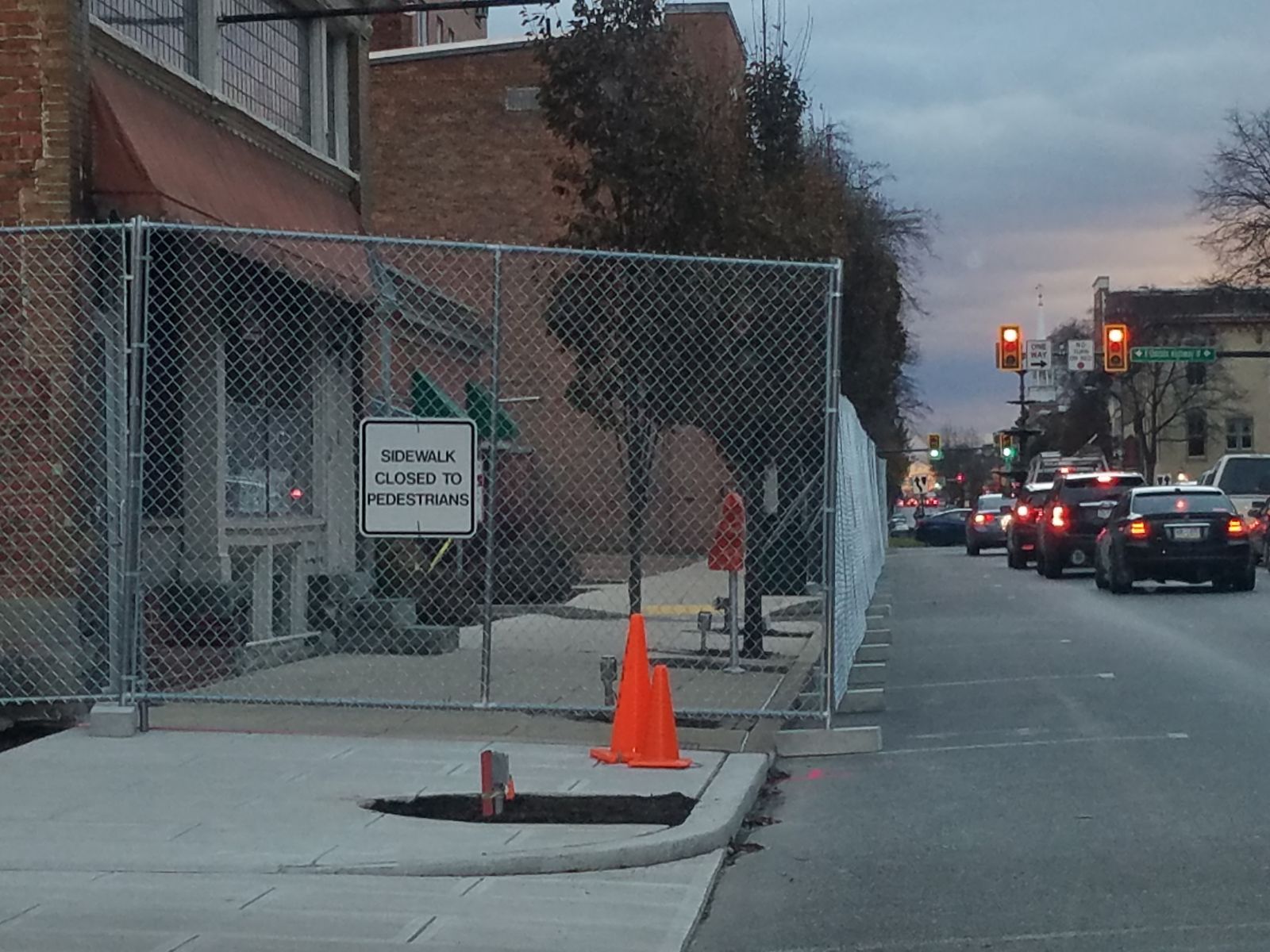 Sidewalk fencing along Main Street in Chambersburg with closed to pedestrian traffic sign.