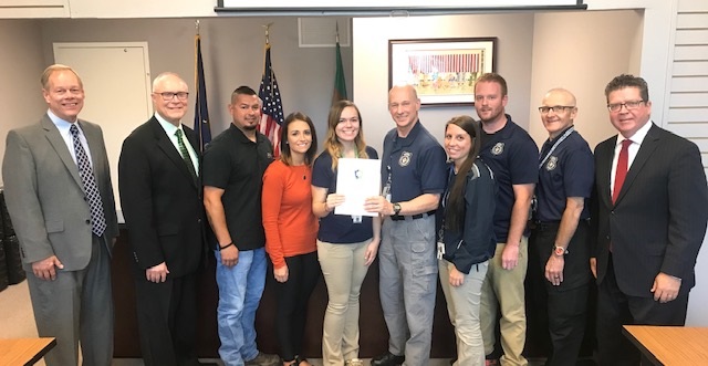 Above photo, left to right: Commissioner Bob Ziobrowski, Commissioner Bob Thomas, Jeremy Woodring, Amanda Woodring, 911 Dispatcher Makenzie Cleary, DES Director John Thierwechter, Barb Harshman, Will Smith, Jake Crider, Commissioner Chairman Dave Keller