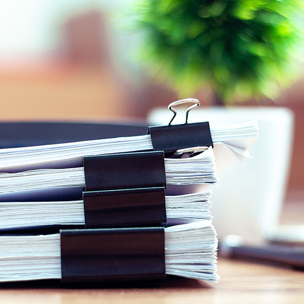 Stack of documents placed on a business desk in a business office.