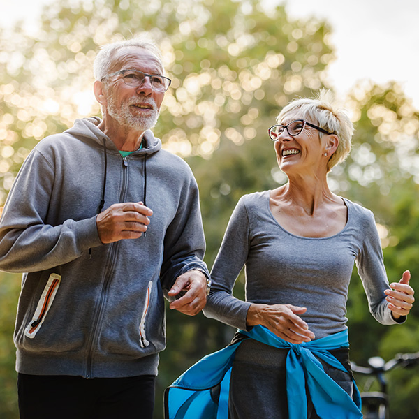 Smiling senior couple jogging in the park