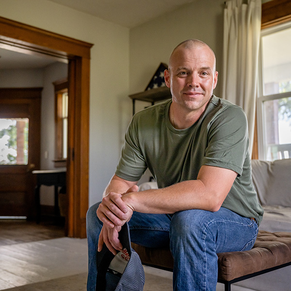 Marine veteran at home with family poses for portrait.