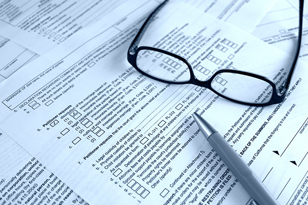 Glasses and a pen on top of a legal petition