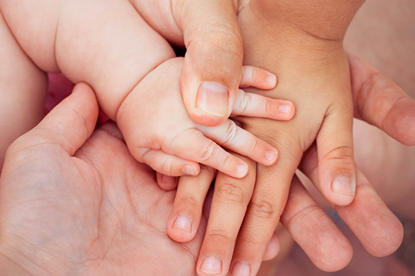 A close up of the  hands of a family.